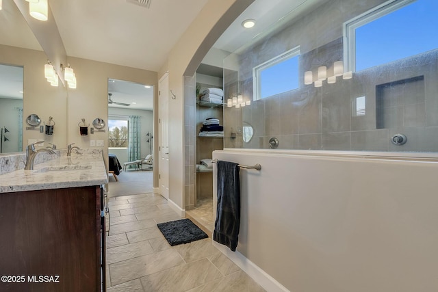 ensuite bathroom featuring a ceiling fan, visible vents, walk in shower, vanity, and ensuite bathroom