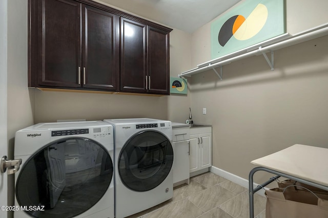 laundry room featuring a sink, baseboards, cabinet space, and washing machine and clothes dryer