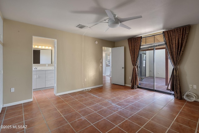 tiled spare room featuring baseboards, a ceiling fan, a sink, and visible vents