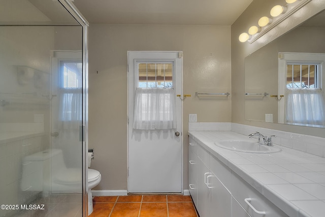 bathroom featuring a shower with shower door, vanity, tile patterned floors, and plenty of natural light
