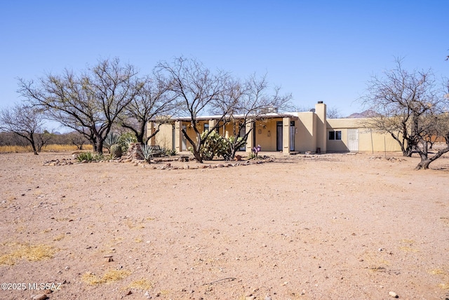 exterior space featuring a chimney and stucco siding