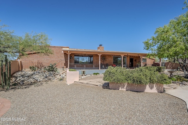 5140 N Via Condesa, Tucson, AZ 85718 - view of front of house featuring a chimney, brick siding, and a patio area