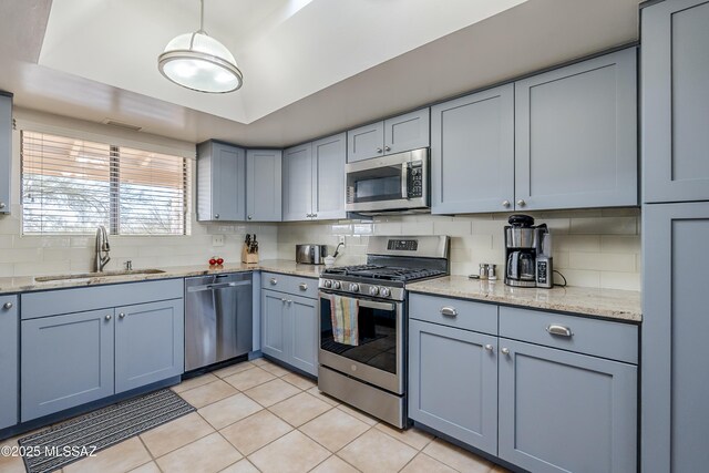 5140 N Via Condesa, Tucson, AZ 85718 - kitchen with stainless steel appliances, gray cabinets, light tile patterned floors, backsplash, and light stone counters