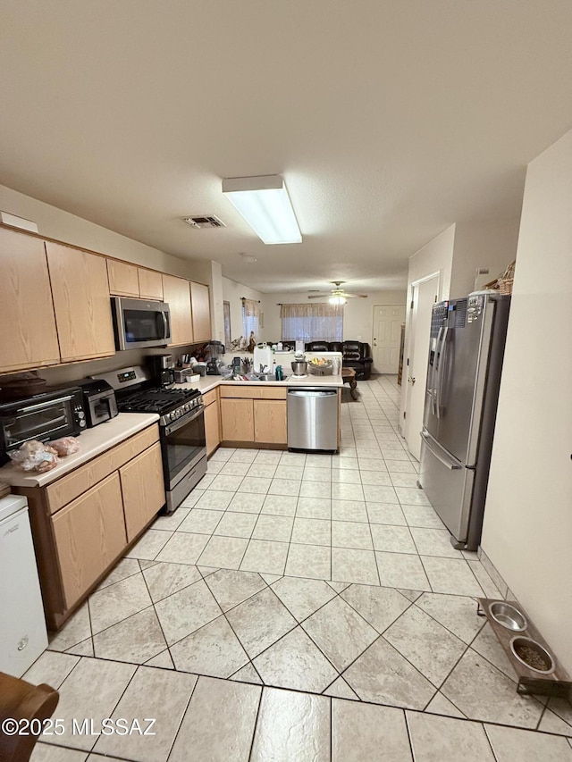 2019 W Calle Cielo De Oro, Tucson, AZ 85746 - kitchen with stainless steel appliances, a peninsula, light countertops, light brown cabinets, and light tile patterned floors