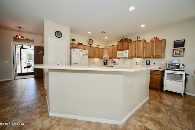 kitchen featuring a large island, baseboards, white appliances, brown cabinets, and light countertops