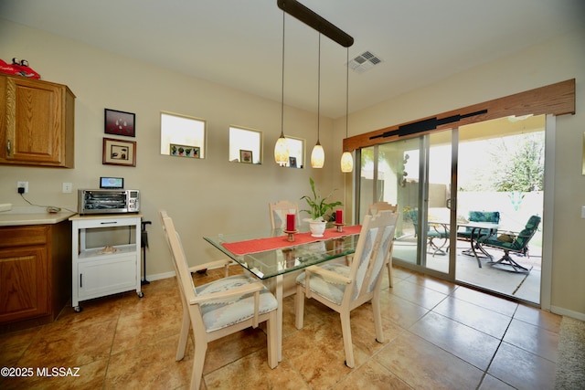 dining space with baseboards, visible vents, a toaster, and light tile patterned floors