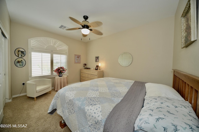 bedroom with a closet, visible vents, light colored carpet, and ceiling fan
