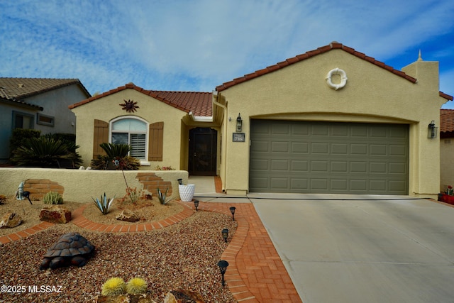 mediterranean / spanish-style house featuring stucco siding, an attached garage, concrete driveway, and a tiled roof