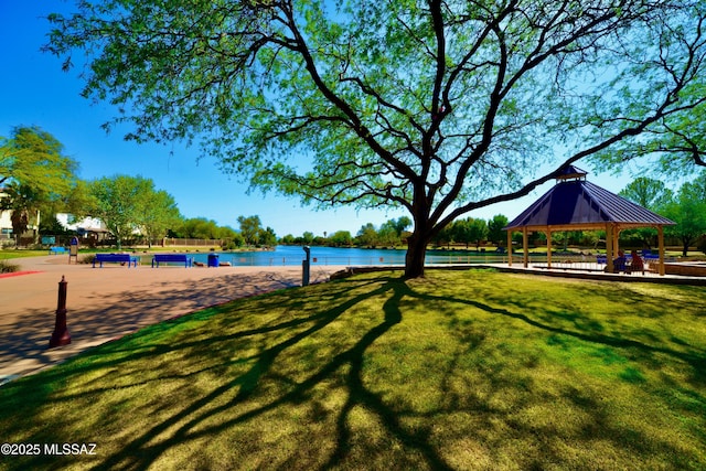 view of property's community with a gazebo, a lawn, and a water view