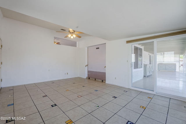 empty room with light tile patterned floors, vaulted ceiling, and ceiling fan