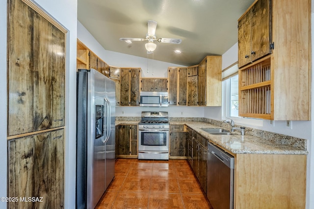 kitchen with light stone counters, a ceiling fan, open shelves, a sink, and stainless steel appliances
