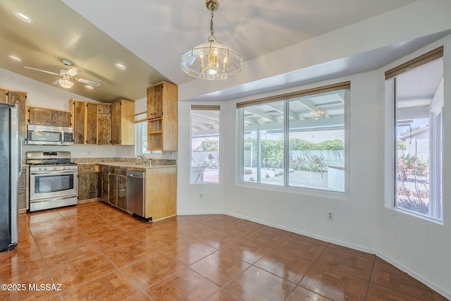 kitchen featuring lofted ceiling, stainless steel appliances, light countertops, and plenty of natural light