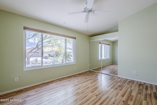 unfurnished bedroom featuring wood finished floors, a closet, and baseboards