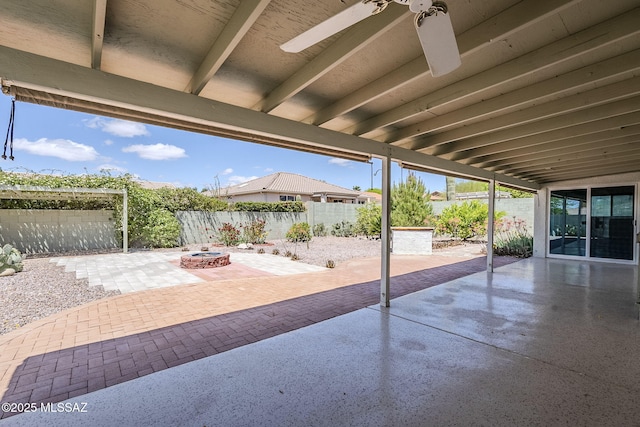 view of patio with a ceiling fan, a fenced backyard, and an outdoor fire pit