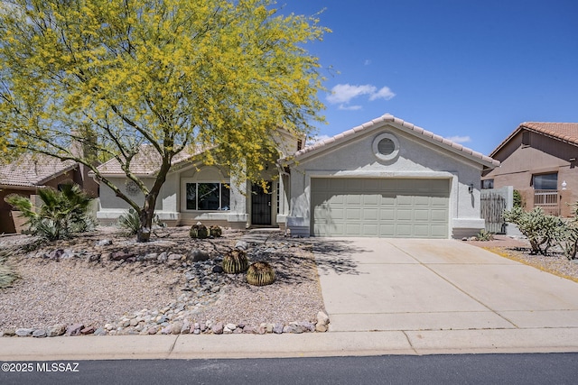 view of front of home with an attached garage, a tile roof, stucco siding, and concrete driveway