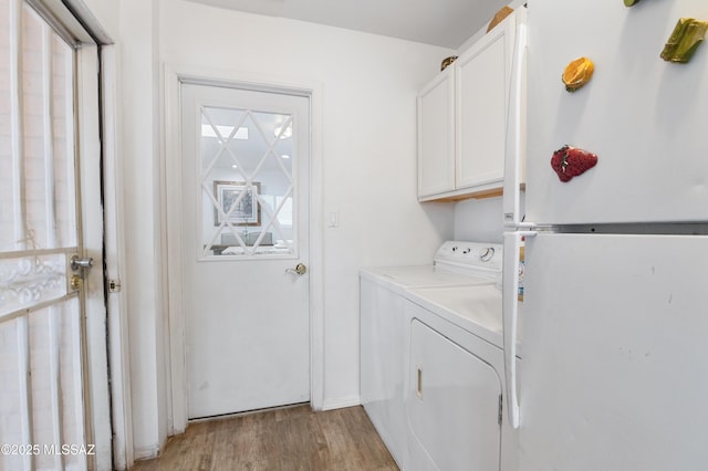889 Paseo Los Mochis Unit 10, Rio Rico, AZ 85648 - clothes washing area featuring washing machine and dryer, light wood finished floors, and cabinet space