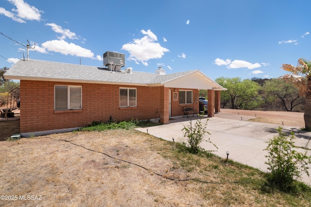 889 Paseo Los Mochis Unit 10, Rio Rico, AZ 85648 - rear view of property with a chimney, a shingled roof, central air condition unit, a patio, and brick siding
