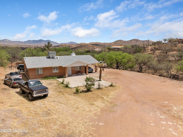 889 Paseo Los Mochis Unit 10, Rio Rico, AZ 85648 - view of front of home with brick siding, central air condition unit, a chimney, and a mountain view
