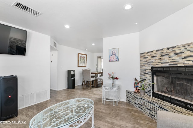 889 Paseo Los Mochis Unit 10, Rio Rico, AZ 85648 - living area featuring a tiled fireplace, wood finished floors, visible vents, and recessed lighting