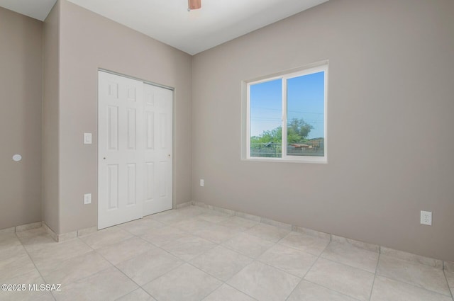 358 W Elvira Rd, Tucson, AZ 85756 - unfurnished bedroom featuring a closet, light tile patterned floors, baseboards, and a ceiling fan