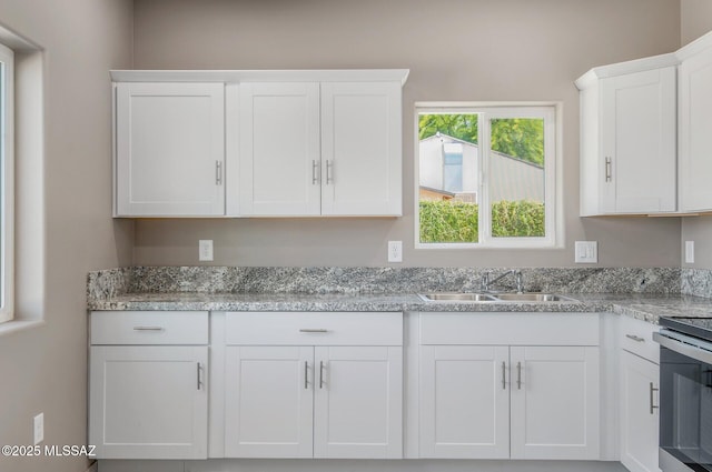 358 W Elvira Rd, Tucson, AZ 85756 - kitchen featuring white cabinets, stove, and a sink