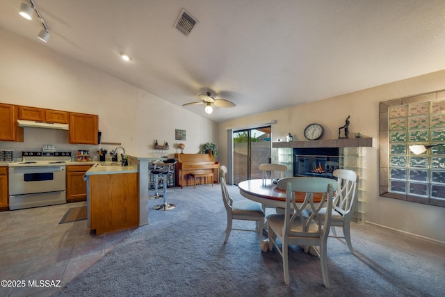 10101 E Bryonwood Ln, Tucson, AZ 85730 - dining room featuring track lighting, a fireplace, a ceiling fan, lofted ceiling, and visible vents