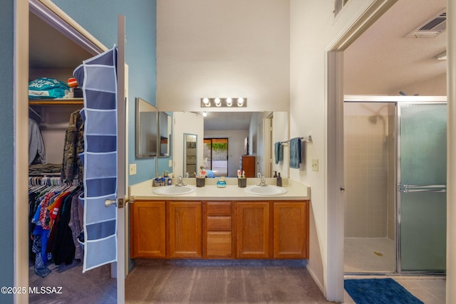 10101 E Bryonwood Ln, Tucson, AZ 85730 - full bathroom with double vanity, visible vents, a shower stall, and a sink