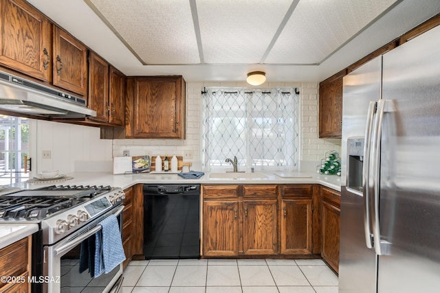 kitchen featuring a sink, appliances with stainless steel finishes, under cabinet range hood, and light countertops