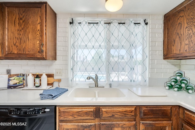 kitchen featuring tasteful backsplash, dishwasher, light countertops, and a sink