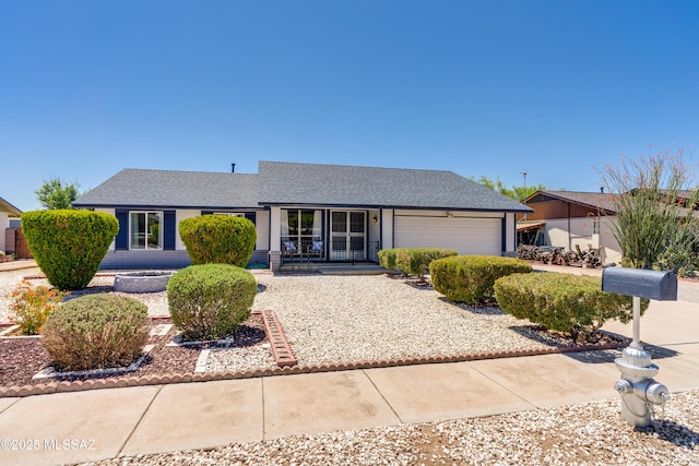 ranch-style house featuring roof with shingles, covered porch, concrete driveway, and a garage
