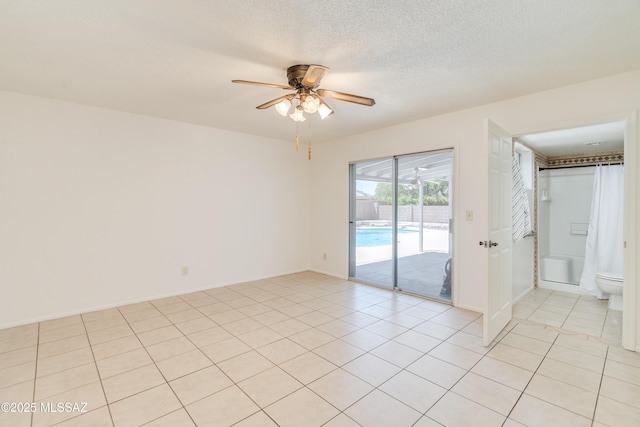 empty room featuring light tile patterned flooring, a ceiling fan, a textured ceiling, and baseboards