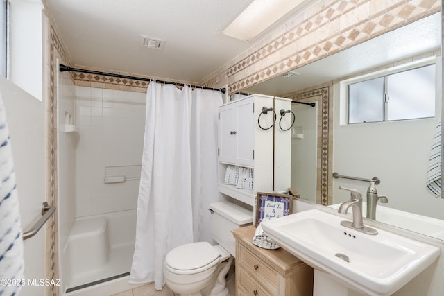 full bath featuring visible vents, a shower with shower curtain, toilet, and a sink