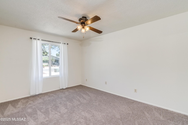 carpeted empty room featuring baseboards, ceiling fan, and a textured ceiling
