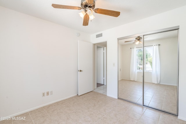unfurnished bedroom featuring light tile patterned floors, a closet, visible vents, and a ceiling fan