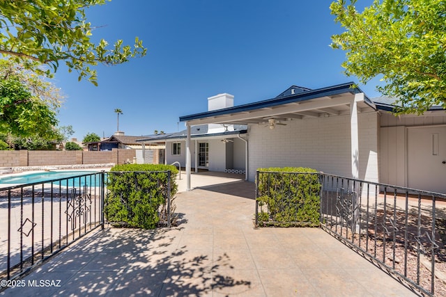 exterior space with ceiling fan, a fenced backyard, and a fenced in pool