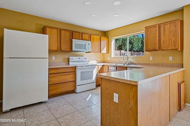 kitchen featuring a sink, white appliances, light countertops, a peninsula, and recessed lighting