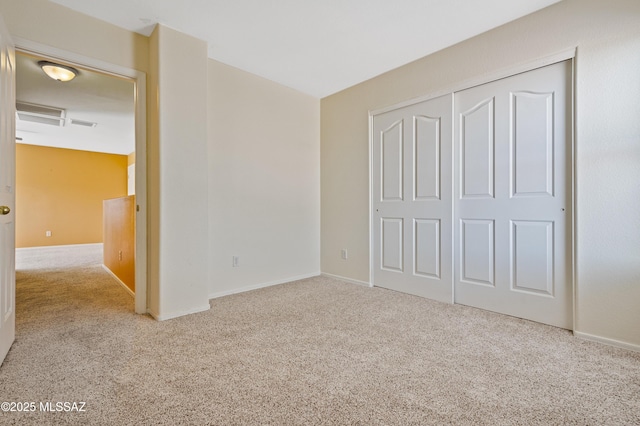 unfurnished bedroom featuring baseboards, carpet, and a closet