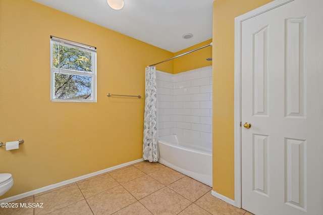 bathroom with shower / bath combo with shower curtain, baseboards, tile patterned flooring, and toilet