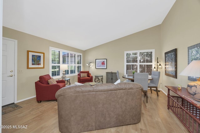 living area featuring light wood-type flooring, plenty of natural light, and baseboards