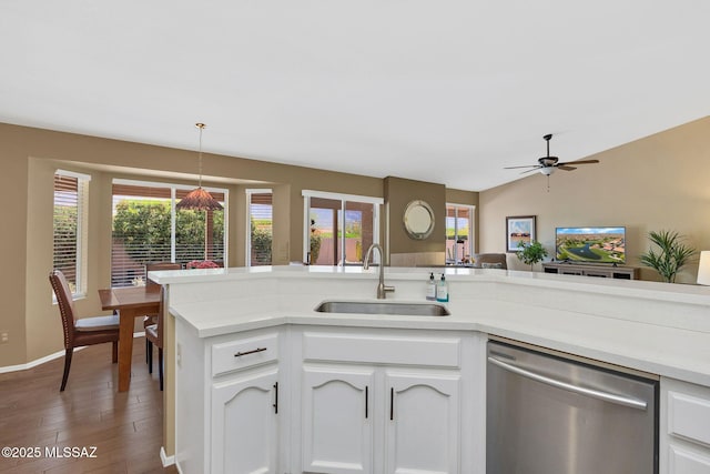 kitchen with dishwasher, a sink, white cabinetry, wood finished floors, and light countertops