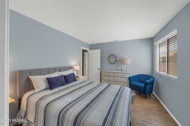 bedroom featuring visible vents, wood finished floors, and baseboards