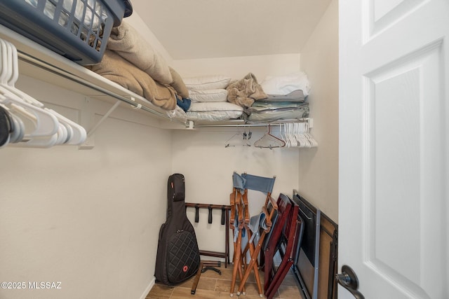 walk in closet with wood finished floors