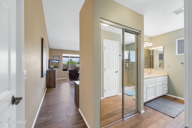 bathroom with vanity, baseboards, visible vents, and wood finished floors