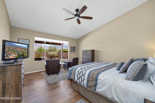 bedroom with lofted ceiling, baseboards, a ceiling fan, and wood finished floors