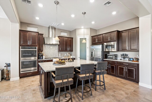 660 W Aviator Crossing Dr, Oro Valley, AZ 85755 - kitchen featuring stainless steel appliances, visible vents, decorative backsplash, and wall chimney exhaust hood