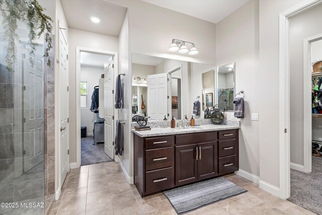 660 W Aviator Crossing Dr, Oro Valley, AZ 85755 - full bathroom with vanity, baseboards, a tile shower, and a walk in closet