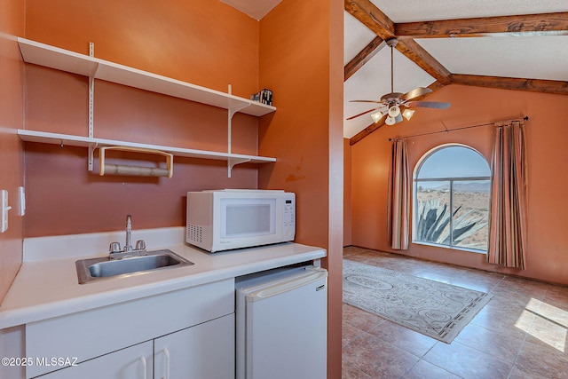 washroom with tile patterned flooring, a ceiling fan, a sink, and wet bar