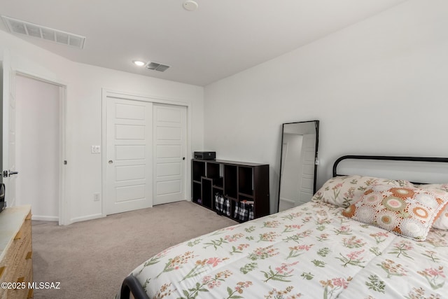 bedroom with a closet, visible vents, carpet floors, and baseboards
