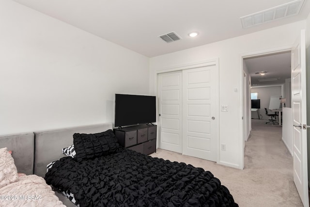 bedroom with light colored carpet, visible vents, recessed lighting, and a closet