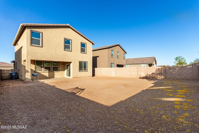 back of house featuring stucco siding and a fenced backyard
